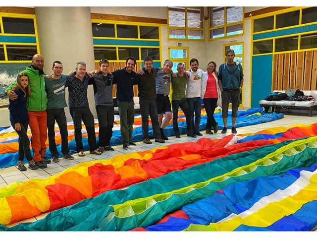 Groupe de parapentistes dans la salle de réception. La surface de la salle permet de replier les voiles à l' intérieur.